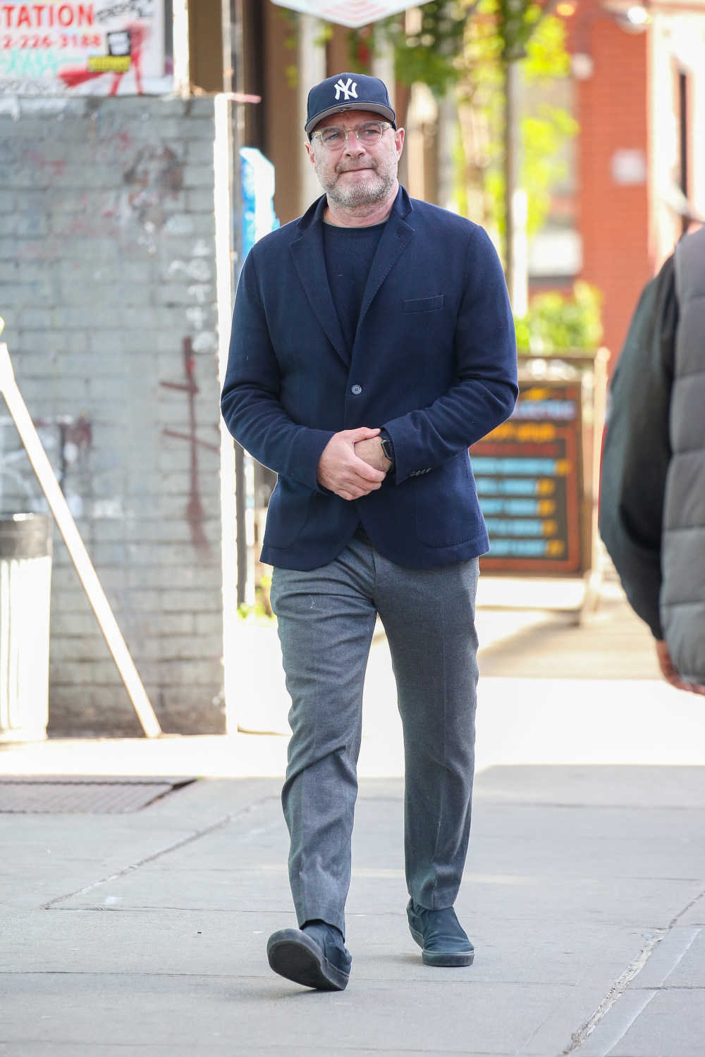 ニューヨークの街角で見かけたのは俳優リーヴ・シュレイバー。ネイビーのアンコンジャケットにグレーのウールパンツを合わせた、カッチリとした大人の着こなし。