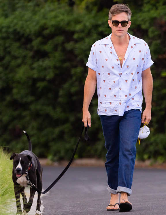 愛犬の散歩をするクリスは、デニムにビーサンのリラックススタイル。普通ならここに楽ちんTシャツを合わせがちだけど、彼が選んだのは開襟シャツ。